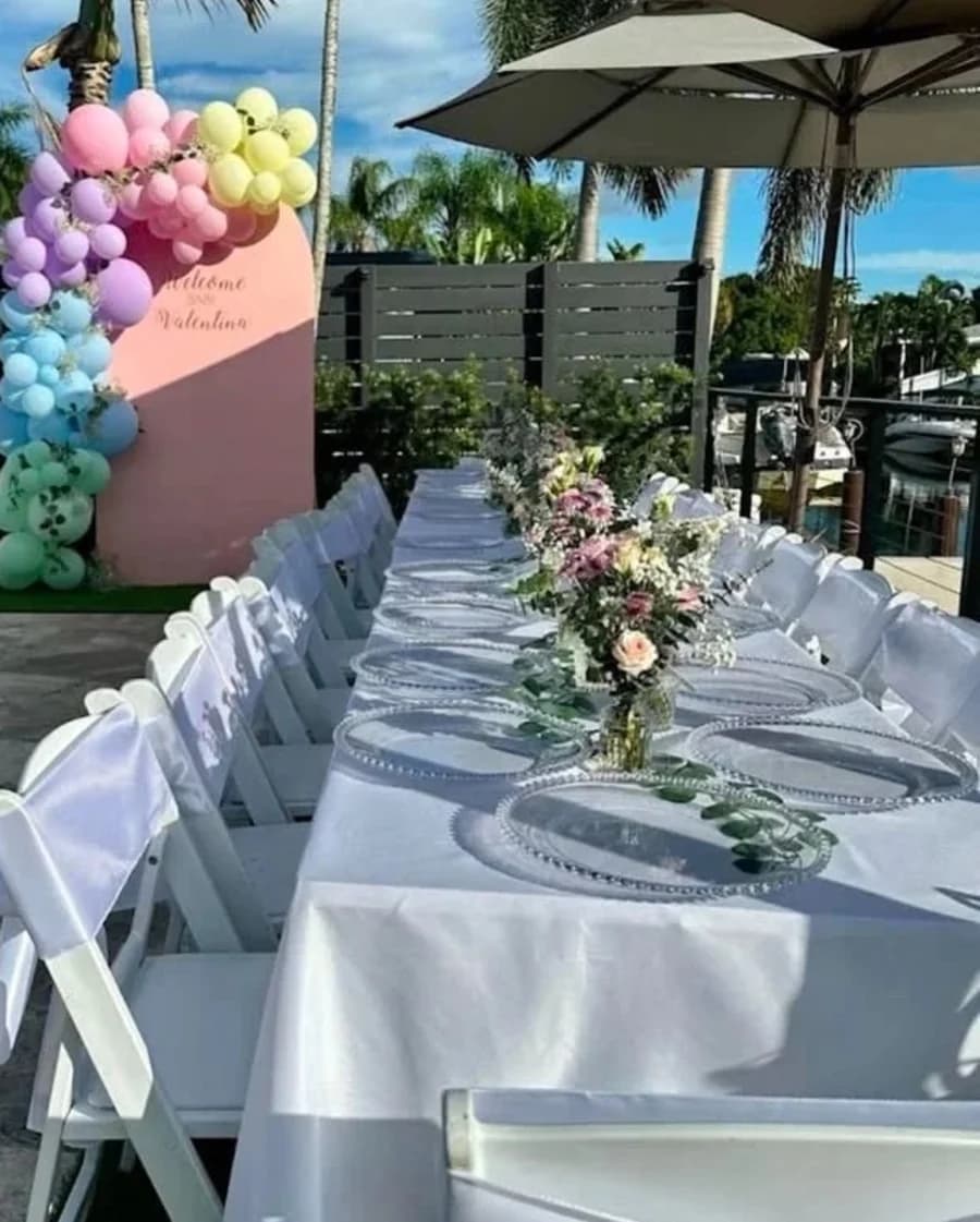 Garden birthday table setup with white chairs