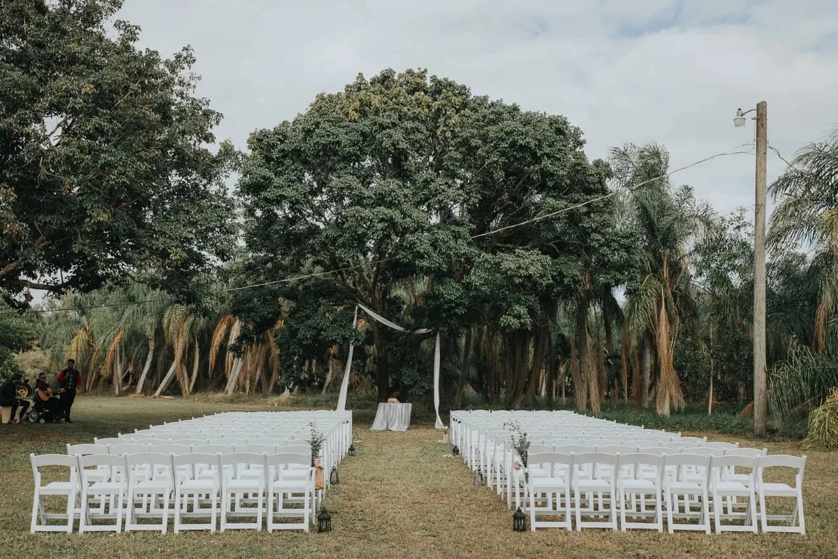 Outdoor ceremony setup with white chairs