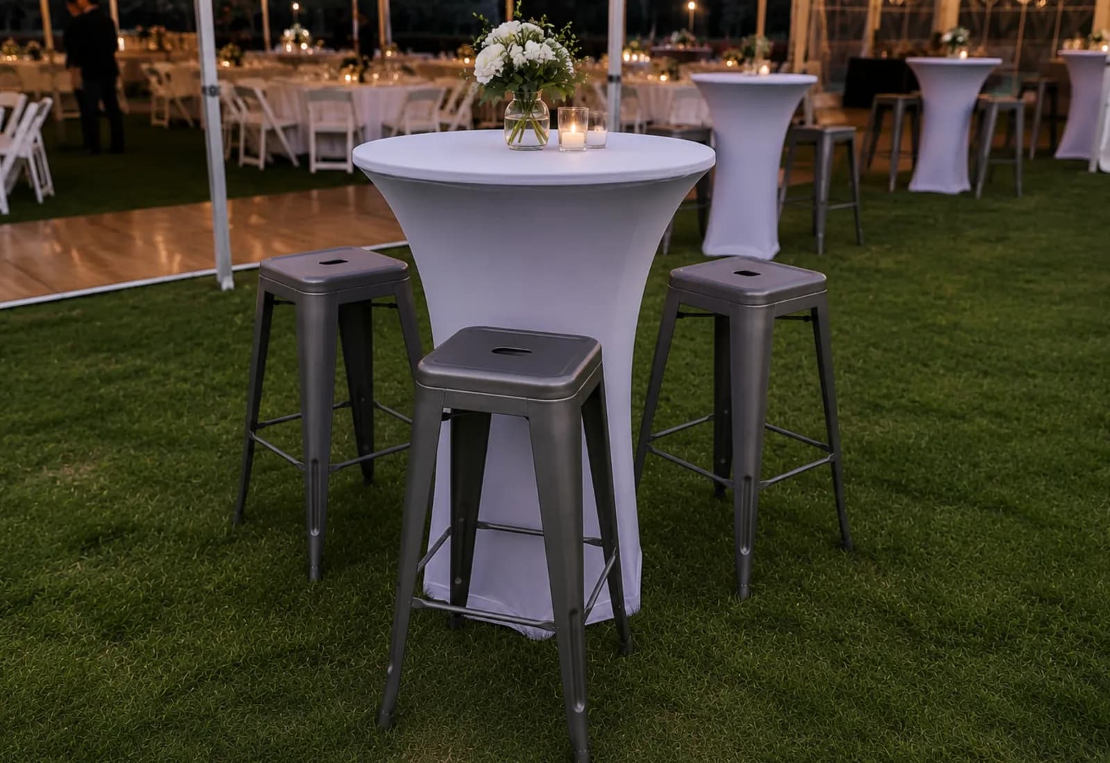 Grey bar stools grouped around cocktail tables at a marquee event