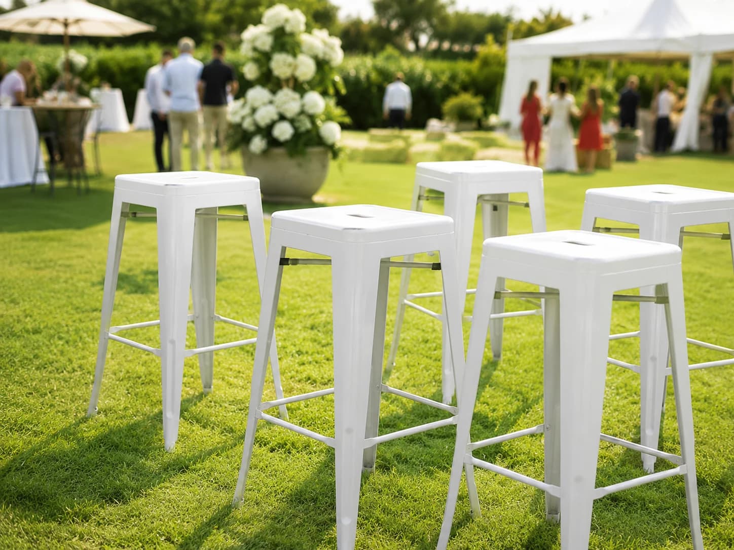 White bar stools set on grass for an outdoor event