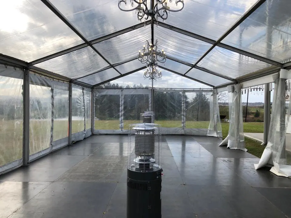 Outdoor gas heater positioned beside a white marquee for an evening event